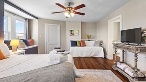 A hotel room with two beds, a ceiling fan, a television, and a large window. - Serene, Smart, Spacious. Near Downtown, In A Quiet Neighborhood (Pittsburgh)
