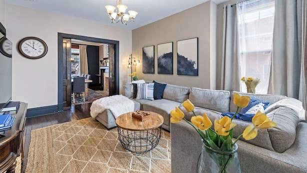 A modern living room with a sofa, coffee table, and artwork on the wall. - Serene, Smart, Spacious. Near Downtown, In A Quiet Neighborhood (Pittsburgh)