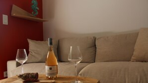 Ett rum med ett träbord, två vinglas, en vinflaska och en bit kött på en skärbräda.