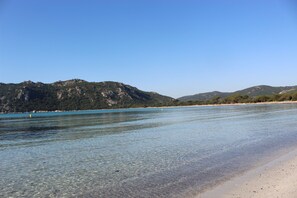 A beach with clear water, sandy shore, and mountains in the background. - A CASA DI PALOMBAGGIA - Heated swimming pool - 3 / 4 persons (Porto-Vecchio)