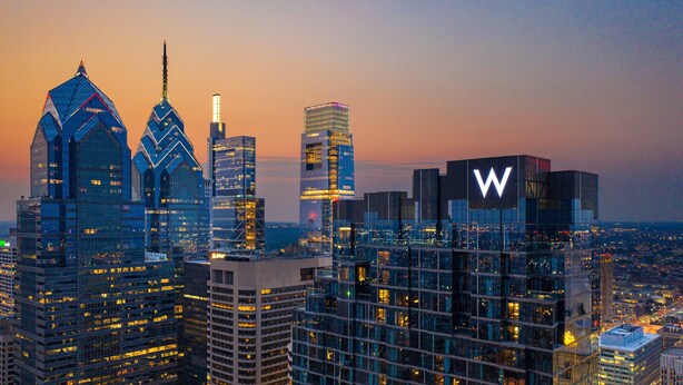 A cityscape with modern high-rise buildings, including a prominent building with a large 'W' sign.