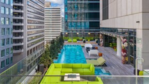 A rooftop pool area with a green sofa, lounge chairs, and a view of surrounding high-rise buildings. - W Philadelphia (Philadelphia)