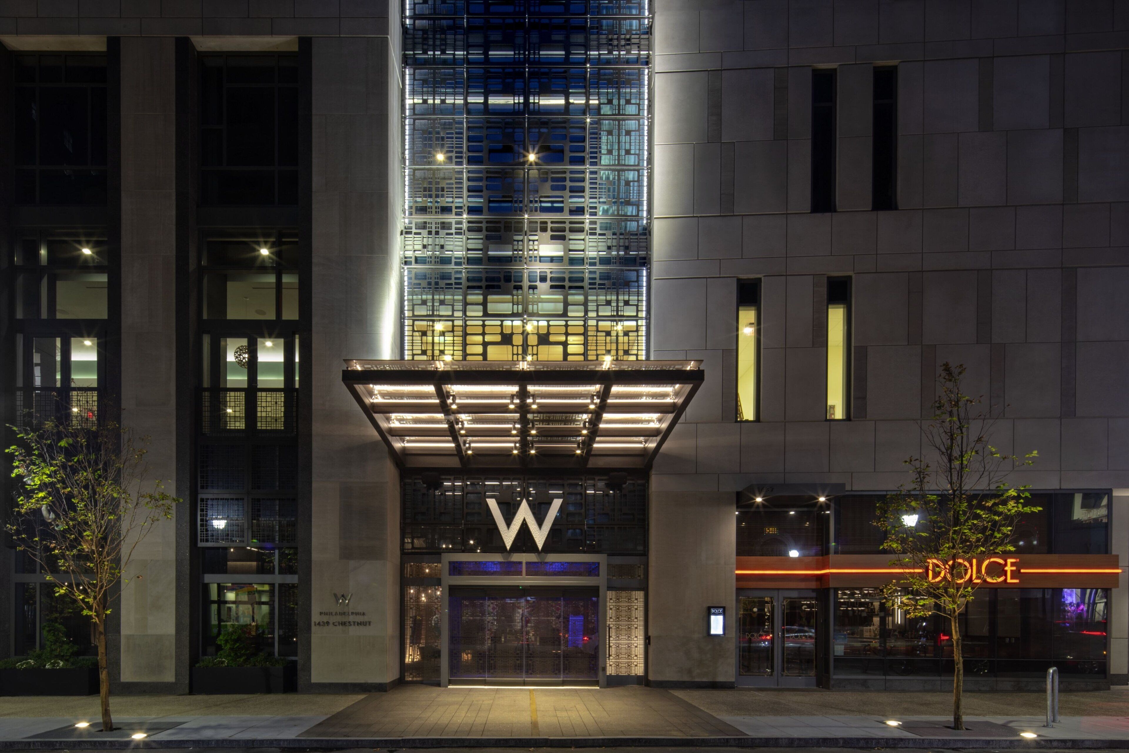 A modern building with a prominent 'W' logo, a glass facade, and a 'Dolce' sign.