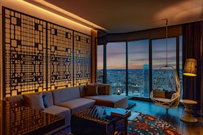 A modern living room with a large window, a decorative wall panel, a sofa, a hanging chair, and a coffee table.