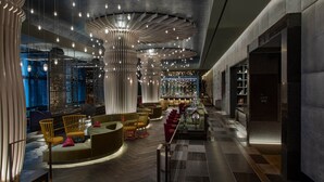 A modern interior with a bar area, seating, and a staircase. - W Philadelphia (Philadelphia)