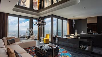 A spacious living area with a large window offering a city view, a modern sofa, a yellow chair, and a unique coffee table.