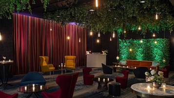 A modern lounge area with striped curtains, a reception desk, and a green wall.