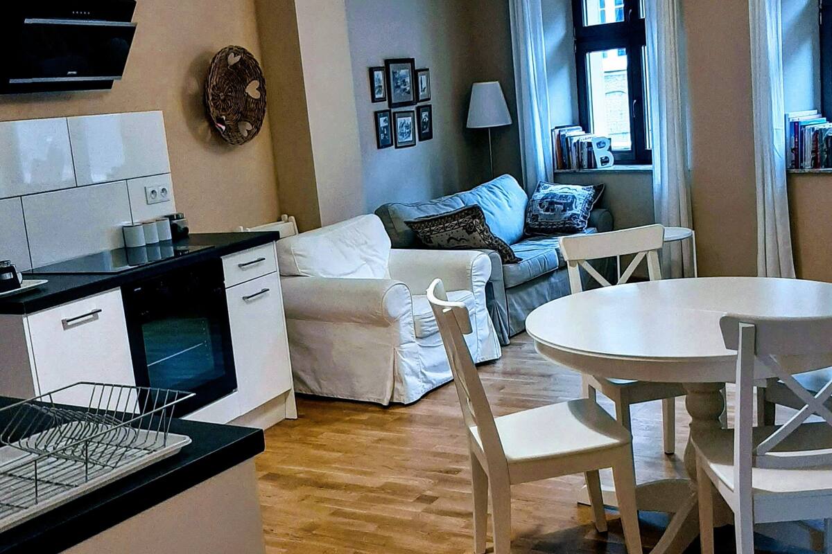 Un espacio habitable compacto con kitchenette, comedor y sofá.