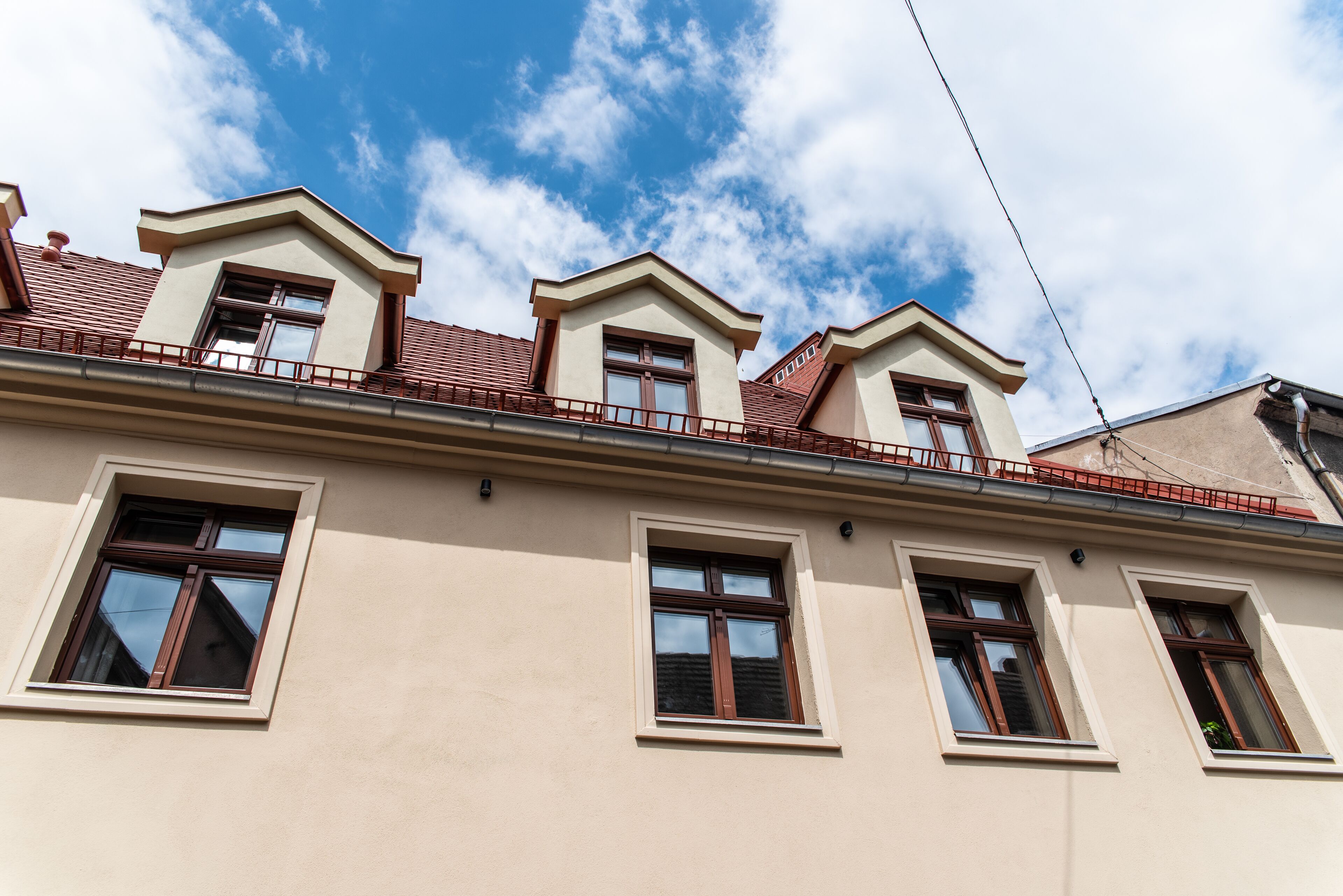 A building with a flat roof, multiple windows, and a balcony.
