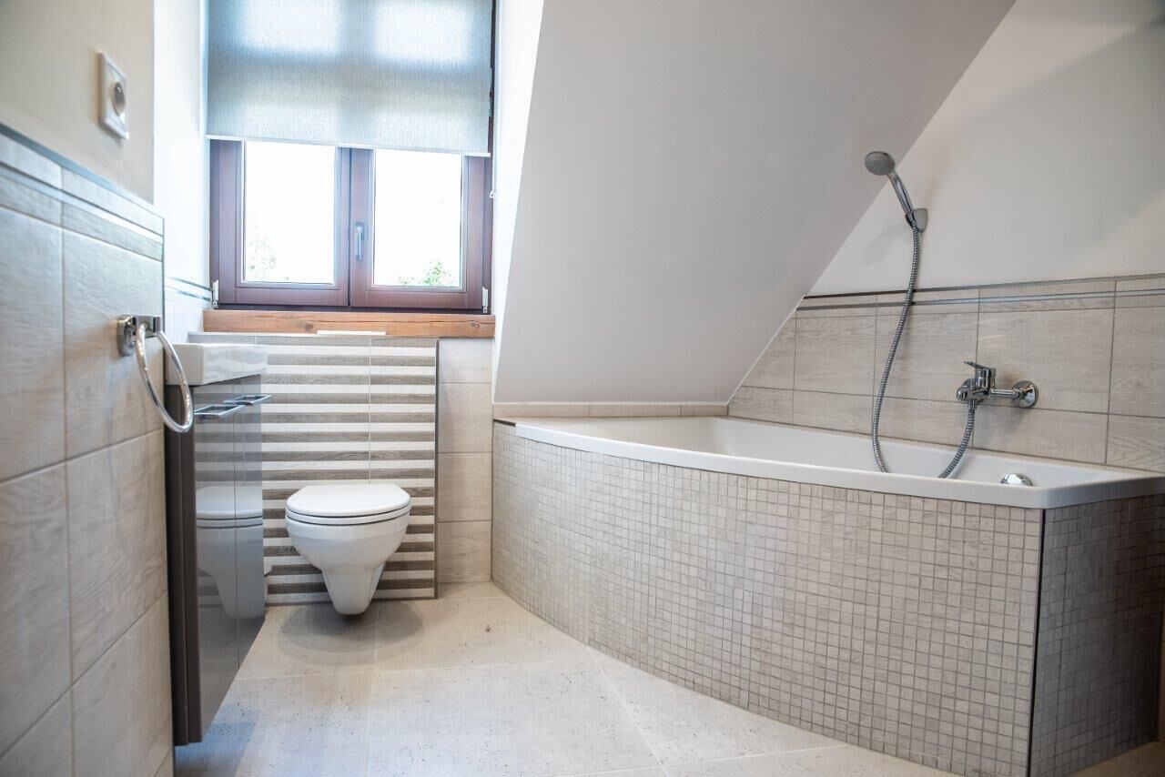 Une salle de bain moderne équipée de toilettes, d’une baignoire et d’une douche.