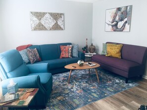 Relax in this stylish living room with a blue sofa, coffee table, and colorful rug.