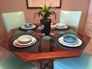 Enjoy meals in this inviting dining area with a round table, comfortable chairs, and a beautiful potted plant.