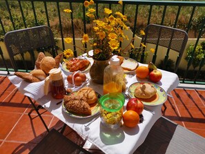 A table set with food and drinks on a terrace with a view of greenery. - Happy Home Obidos (Obidos)