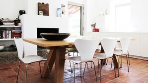 A modern kitchen with a wooden table, white chairs, and a black bowl. - Typical Tuscan farmhouse in charming position between Panzano -Greve in Chianti  (Greve in Chianti)