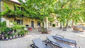 An outdoor patio area with a grill, seating, and potted plants. - Near L'Isle-sur-la-Sorgue, quiet old Provençal Mas, 19 Pers. Swimming pool. (Le Thor)