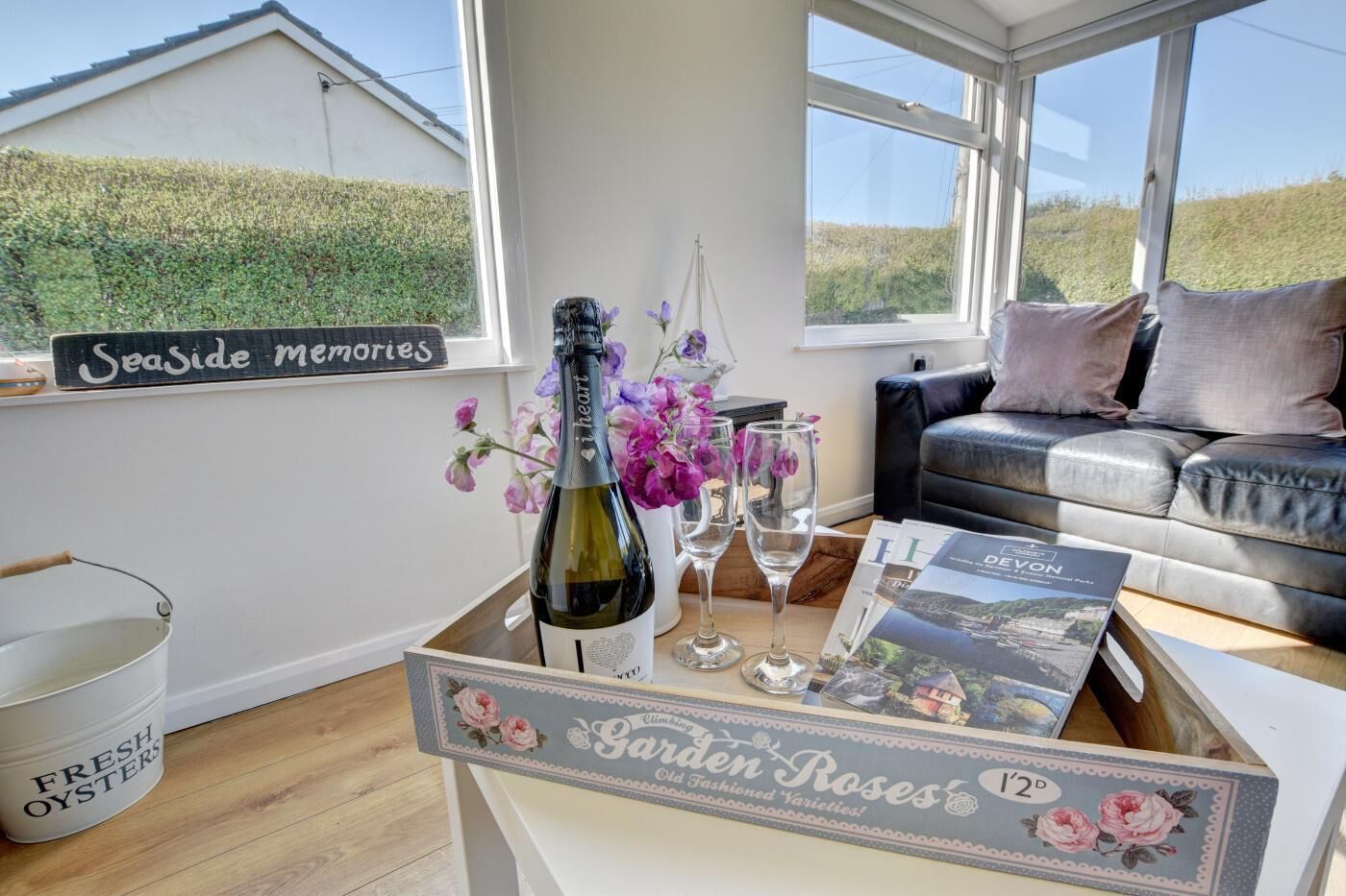 A cozy living room with a view of the countryside, a bottle of wine, and a tray of oysters.