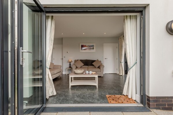A modern living room with a sofa, coffee table, and a painting on the wall.