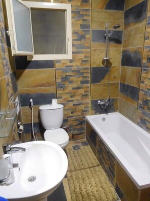 Un baño con inodoro, lavabo y bañera.