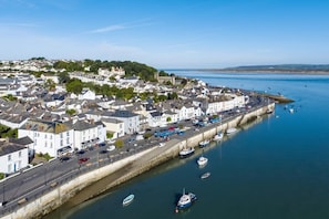 A coastal town with a harbor, white buildings, and a road along the waterfront.