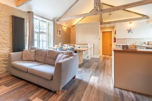 Un salon moderne comprenant un canapé, un coin repas et une cuisine.