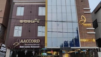Een meerlaags gebouw met borden waarop 'AAccord Capitalo' en 'AAccord Multi Cuisine Restaurant' staan.