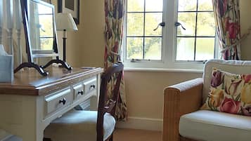 Una habitación con escritorio, silla y ventana con cortinas.