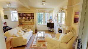 Een gezellige woonkamer met een open haard, een televisie en een boekenplank vol boeken.