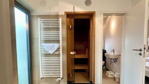 Un bagno moderno dotato di doccia, WC e lavandino.