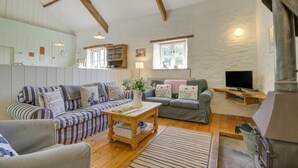 A cozy living room with two sofas, a coffee table, a TV, and a wood-burning stove. - 3 Bed in Parracombe (oc-molec) (Parracombe)