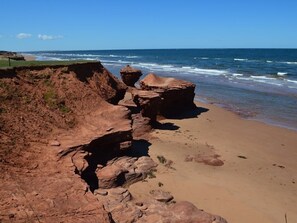 Un paysage côtier caractérisé par des falaises rocheuses et une plage de sable.