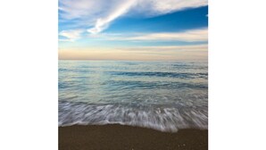 A beach with waves gently lapping onto the shore.