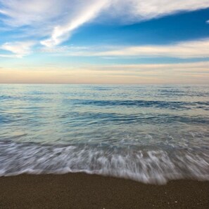 A beach with waves gently lapping onto the shore. - Admiral Building Studio (Mijas)