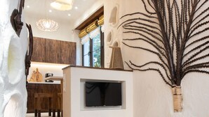 Un interior moderno con una escalera de madera, un televisor de pantalla plana y una planta decorativa.