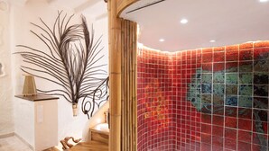 Un baño moderno con una bañera independiente, un banco de madera y una planta decorativa.