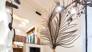 Una sala de estar moderna con una mesa de centro de madera, un televisor montado en la pared y una planta decorativa.