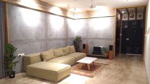 A modern living room with a sectional sofa, a coffee table, and a TV stand.