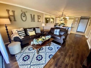 Ein Wohnzimmer mit einer Couch, einem Couchtisch und einem gemusterten Teppich.