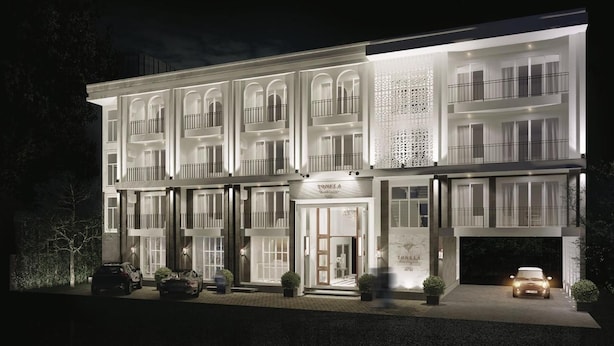 Un hotel de varios pisos con fachada simétrica, ventanas amplias y una entrada central.