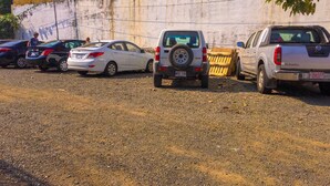 Un estacionamiento con varios coches, incluyendo un SUV blanco y una camioneta.