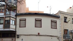 A building with three windows, a door, and a small balcony. - CH Murallas II (Madrid)