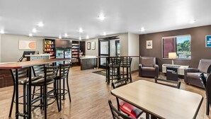 A spacious indoor area with a bar, seating, and a refrigerator.