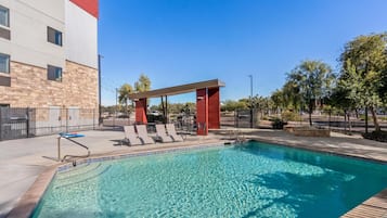 Una piscina al aire libre, tumbonas