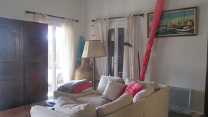 Ein Wohnzimmer mit einem beigen Sofa, einer Lampe und einem Bild an der Wand.