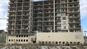 Un edificio residencial de varios pisos con balcones, techo plano y fachada sencilla.