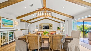 A dining area with a high ceiling, wooden beams, and a central chandelier. - Luxury Home with Pool and Dock for Fishing! (Anna Maria)