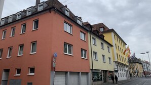 Une rangée de bâtiments colorés, dotés de nombreuses fenêtres et d’une porte de garage fermée.