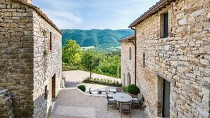 A stone building with a gravel courtyard and outdoor seating.