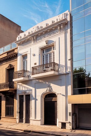 A two-story building with a balcony, large windows, and a garage door.