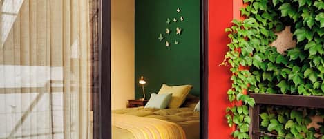 A room with a bed, a nightstand, and a lamp.
