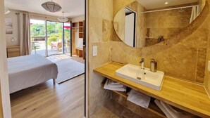 Un baño moderno con un espejo grande, un lavamanos y una ducha.